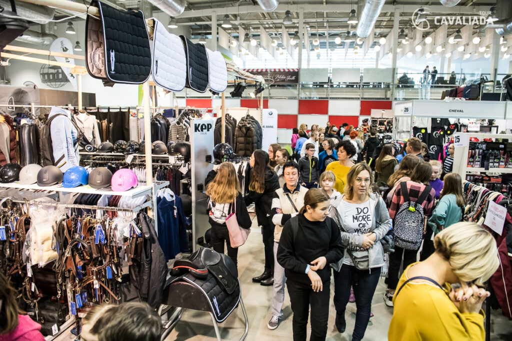 Návštěvníci na CAVALIADA Expo v Poznani vybírají jezdecké vybavení, helmy a doplňky na stáncích vystavovatelů.