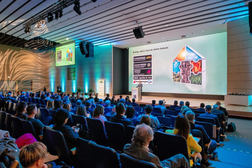 Odborná konference na veletrhu CONSTRUMA v HUNGEXPO Budapest, kde přednášející prezentuje trendy ve stavebnictví a témata udržitelné výstavby před plným auditoriem.
