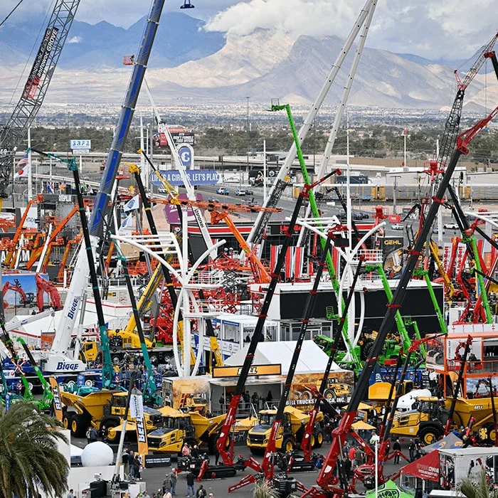 Venkovní výstavní plocha Conexpo 2026 zaplněná stavební technikou, jeřáby, bagry a pracovními stroji různých značek, s horami v pozadí.