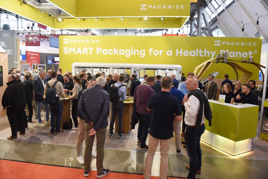 Stánek Packsize na veletrhu LogiMAT v Messe Stuttgart s návštěvníky sledujícími ukázky chytrých obalových řešení.