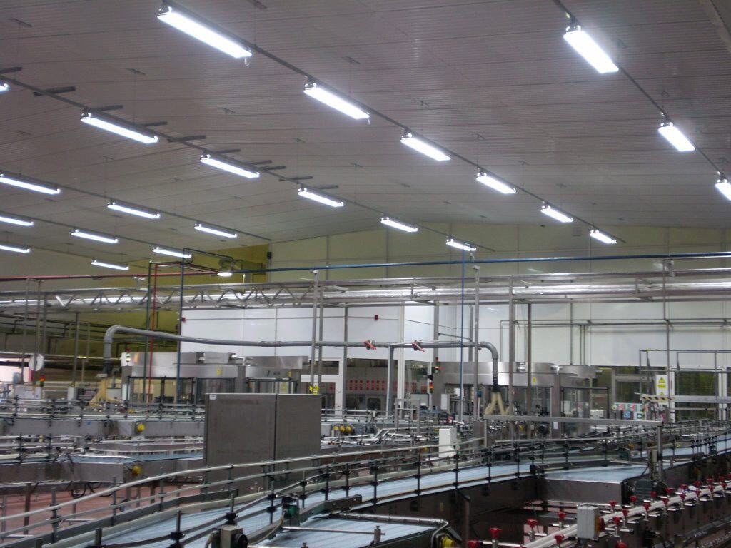 Interiér průmyslové montované haly HUPRO s výrobní technologií, dopravníky a osvětlením pro průmyslový provoz.